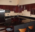 Cherry kitchen cabinets with black appliances